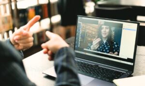 Two people signing to each other via a laptop